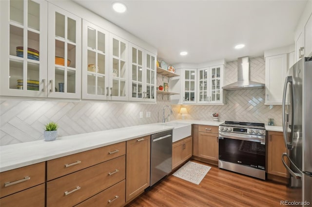 705 S Alton Way Unit 4D, Denver, CO 80247 - kitchen with appliances with stainless steel finishes, wall chimney exhaust hood, a sink, backsplash, and dark wood finished floors