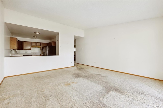 655 S Alton Way Unit 8D, Denver, CO 80247 - unfurnished living room featuring light colored carpet and baseboards