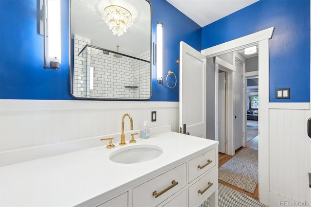 3044 W 40th Ave, Denver, CO 80211 - bathroom featuring a wainscoted wall, vanity, a tile shower, a chandelier, and wood finished floors