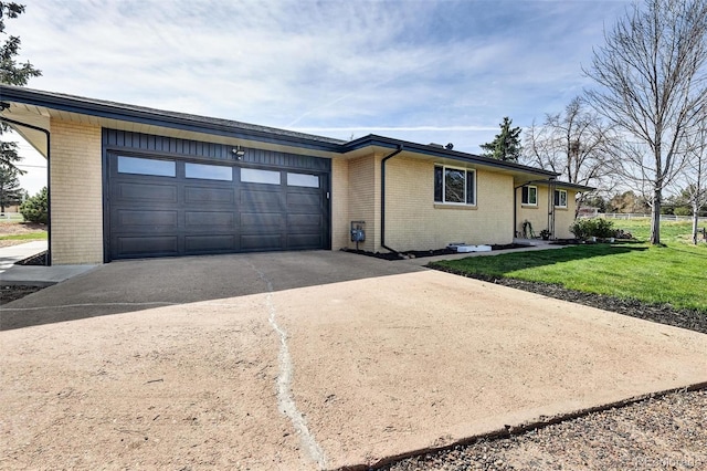 view of front of property featuring brick siding, concrete driveway, a garage, and a front yard