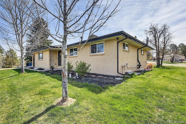 view of front of property featuring brick siding and a front yard