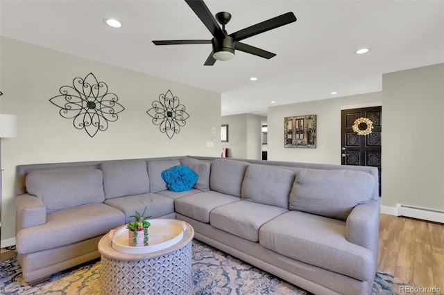 living area featuring a ceiling fan, light wood-style floors, recessed lighting, baseboards, and a baseboard heating unit