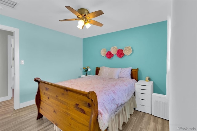 bedroom featuring light wood-type flooring, baseboards, and ceiling fan