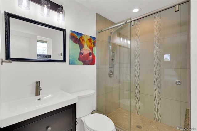 bathroom featuring a stall shower, toilet, and vanity
