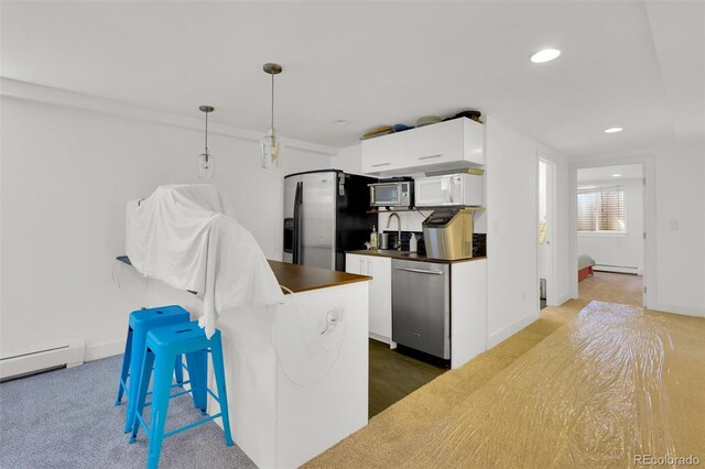 kitchen featuring appliances with stainless steel finishes, dark countertops, white cabinetry, baseboard heating, and recessed lighting