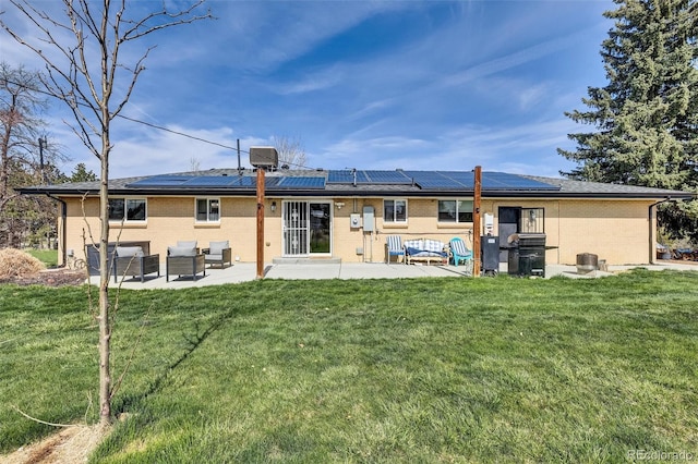 back of property with a patio area, outdoor lounge area, brick siding, and a lawn