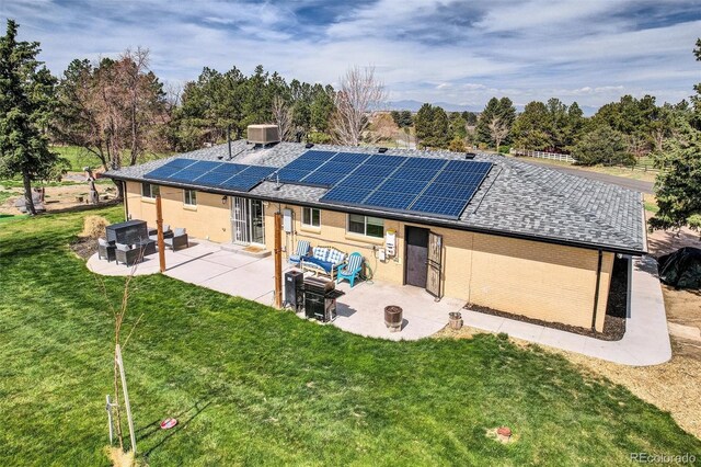 rear view of property with an outdoor living space, a patio, and solar panels