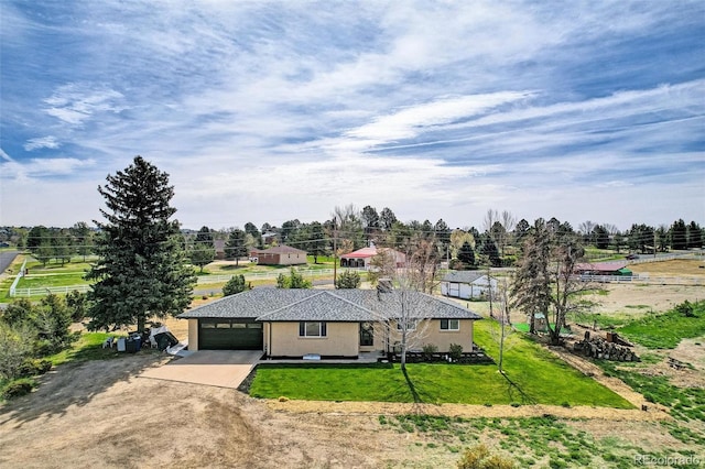 view of front of property with concrete driveway, an attached garage, and a front lawn