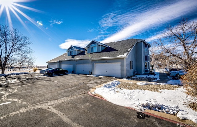 view of snowy exterior featuring a garage