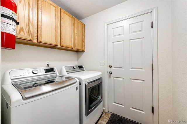 washroom with cabinets and washer and clothes dryer