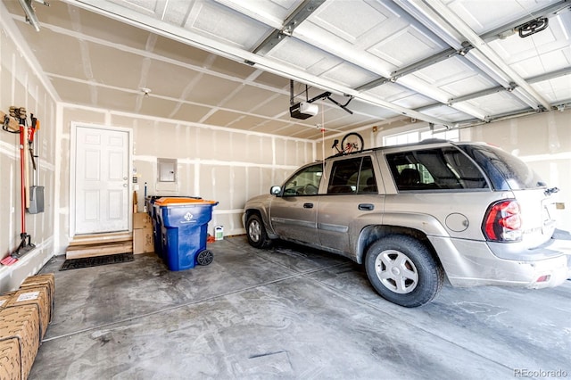 garage featuring electric panel and a garage door opener