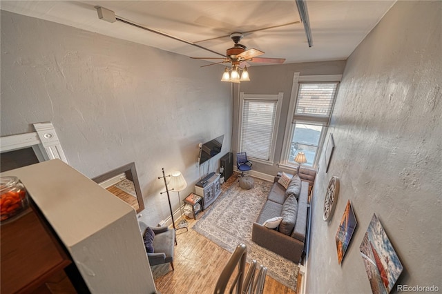 interior space featuring baseboards, a ceiling fan, and wood finished floors