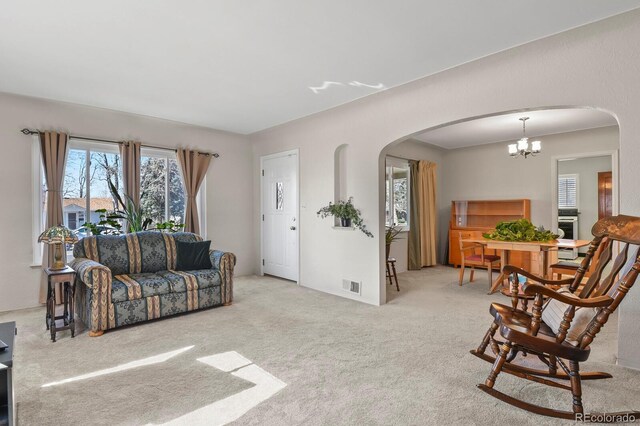 4546 S Logan St, Englewood, CO 80113 - living room featuring arched walkways, carpet flooring, healthy amount of natural light, and a chandelier
