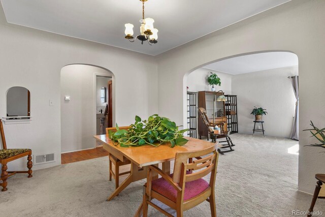 4546 S Logan St, Englewood, CO 80113 - carpeted dining area featuring arched walkways and a chandelier
