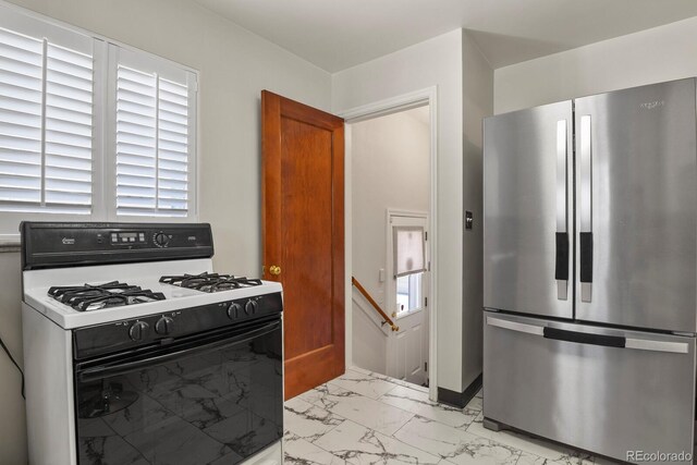 4546 S Logan St, Englewood, CO 80113 - kitchen featuring freestanding refrigerator, gas stove, light marble finish floors, and baseboards