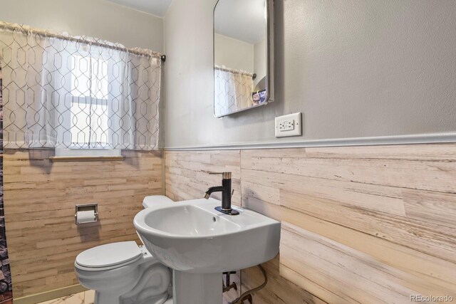 4546 S Logan St, Englewood, CO 80113 - bathroom with wainscoting, toilet, a sink, and wooden walls