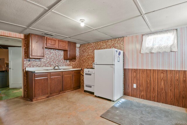4546 S Logan St, Englewood, CO 80113 - kitchen with white appliances, a sink, wallpapered walls, brown cabinets, and a wainscoted wall