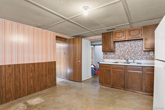 4546 S Logan St, Englewood, CO 80113 - kitchen featuring a sink, wallpapered walls, concrete flooring, light countertops, and freestanding refrigerator