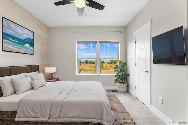 bedroom with ceiling fan, carpet floors, and wooden walls