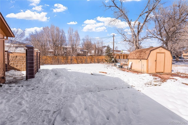 yard covered in snow featuring a storage unit