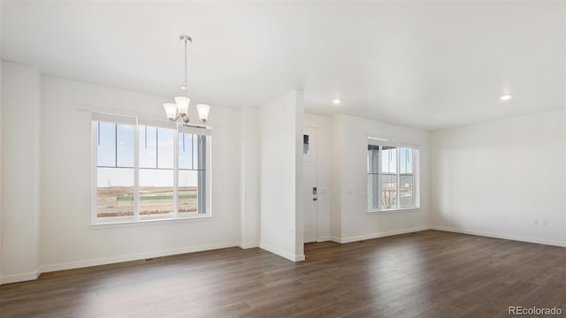 unfurnished room with dark wood-type flooring and a notable chandelier