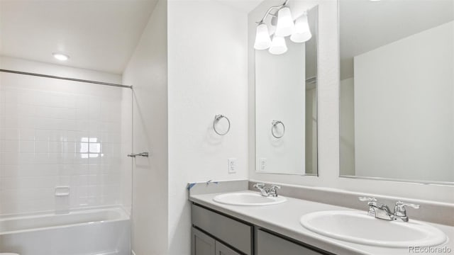 bathroom with tiled shower / bath combo and vanity