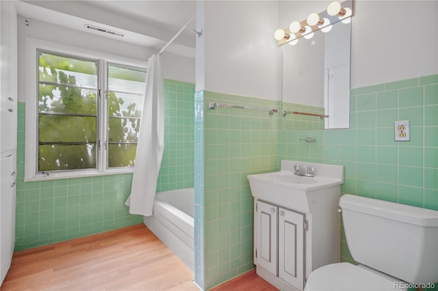 full bathroom featuring vanity, hardwood / wood-style flooring, and tile walls