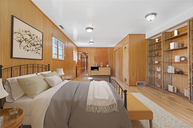 bedroom featuring wood walls and light wood-type flooring