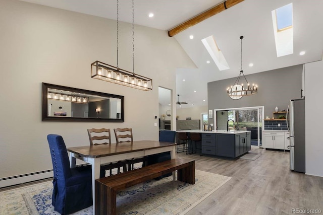 2539 Lake Meadow Dr, Lafayette, CO 80026 - dining area featuring a chandelier, high vaulted ceiling, beam ceiling, a skylight, and light wood-type flooring