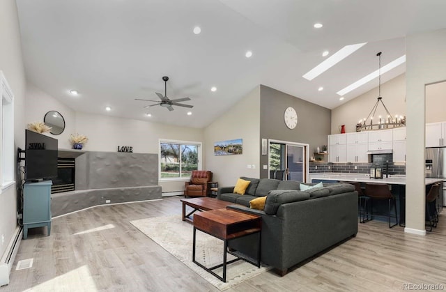 2539 Lake Meadow Dr, Lafayette, CO 80026 - living room with high vaulted ceiling, light wood-style floors, a chandelier, a baseboard heating unit, and a skylight