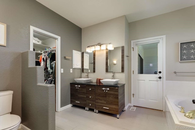 2539 Lake Meadow Dr, Lafayette, CO 80026 - full bath featuring toilet, double vanity, a bathtub, a spacious closet, and tile patterned floors