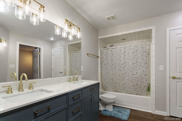 2539 Lake Meadow Dr, Lafayette, CO 80026 - bathroom with wood finished floors, shower / tub combination, toilet, double vanity, and a textured wall