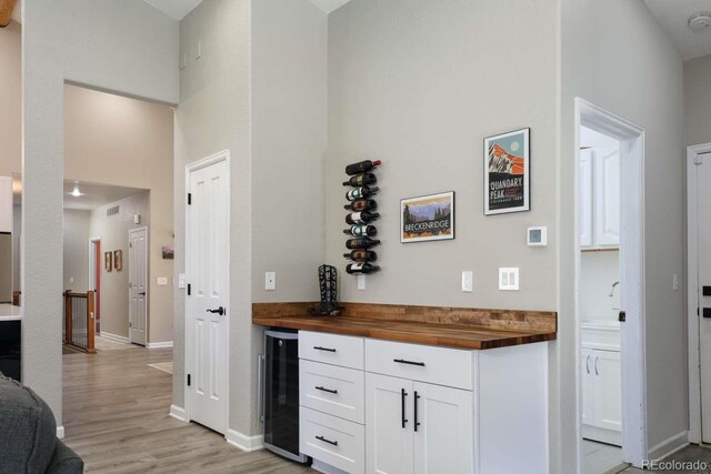 2539 Lake Meadow Dr, Lafayette, CO 80026 - bar area with wine cooler, light wood finished floors, baseboards, and a high ceiling