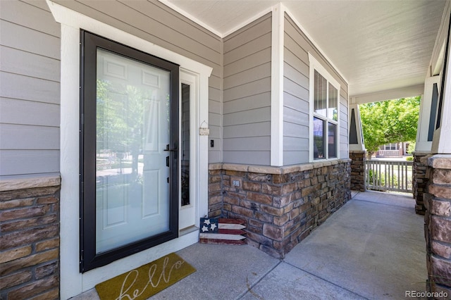 902 Jarvis Dr, Erie, CO 80516 - doorway to property featuring covered porch and stone siding