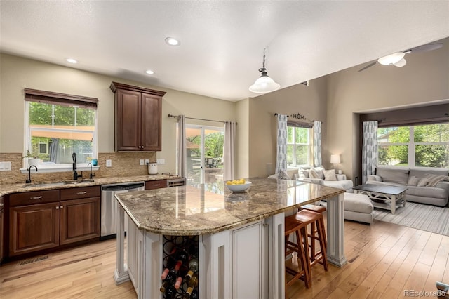902 Jarvis Dr, Erie, CO 80516 - kitchen with dishwasher, a sink, open floor plan, a breakfast bar, and recessed lighting