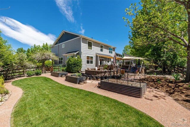 902 Jarvis Dr, Erie, CO 80516 - rear view of property with a vegetable garden and board and batten siding
