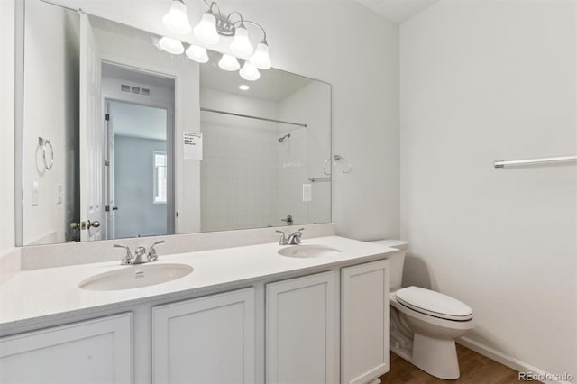 bathroom featuring walk in shower, vanity, wood-type flooring, and toilet