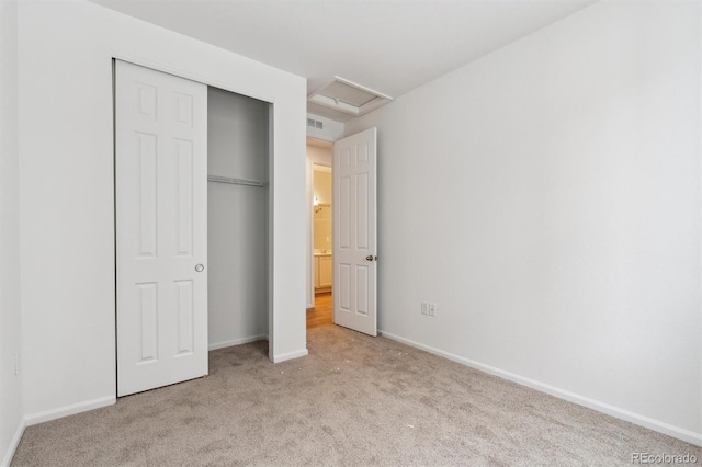 unfurnished bedroom featuring light carpet and a closet