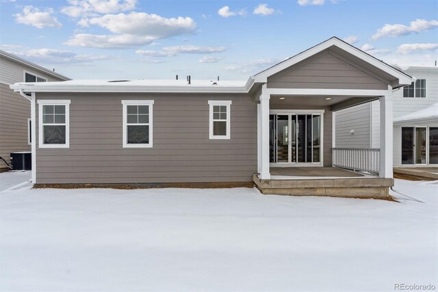 snow covered property with central air condition unit