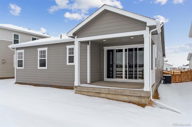 snow covered property with central AC