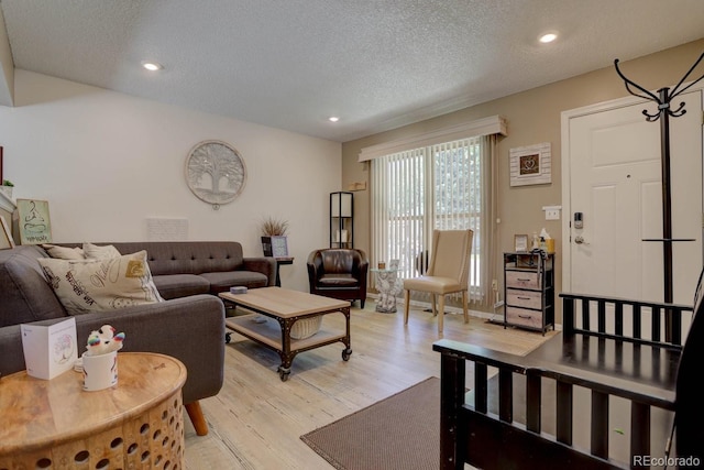 living room with light wood-style floors, recessed lighting, and a textured ceiling