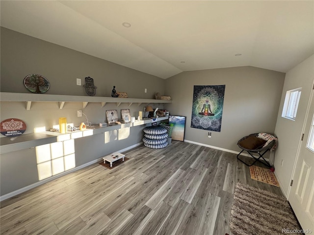 misc room with vaulted ceiling, wood finished floors, and baseboards