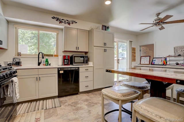 kitchen featuring a ceiling fan, light countertops, a sink, and black appliances