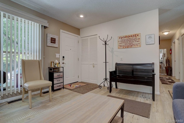 living area featuring a textured ceiling and wood finished floors