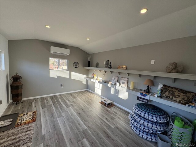 clothes washing area featuring recessed lighting, a wall unit AC, wood finished floors, and baseboards