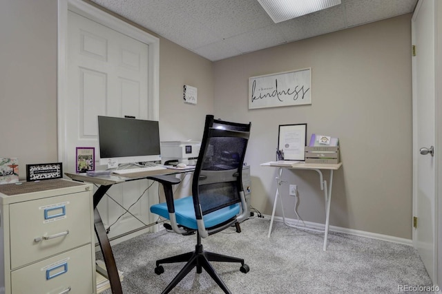 office space featuring a paneled ceiling, baseboards, and carpet flooring