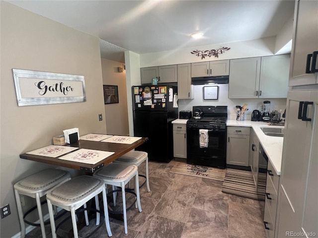 kitchen with light countertops, gray cabinetry, black appliances, a sink, and exhaust hood