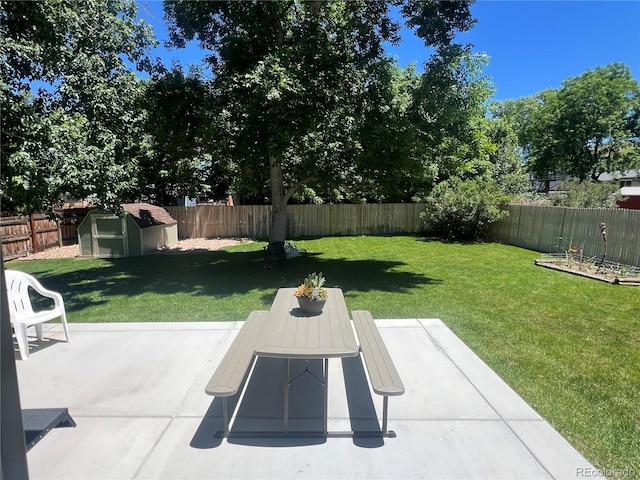 view of yard featuring an outbuilding, outdoor dining space, a patio area, a shed, and a fenced backyard