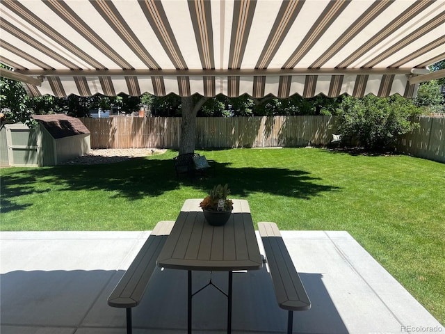 view of yard with a patio, outdoor dining area, fence private yard, an outdoor structure, and a shed