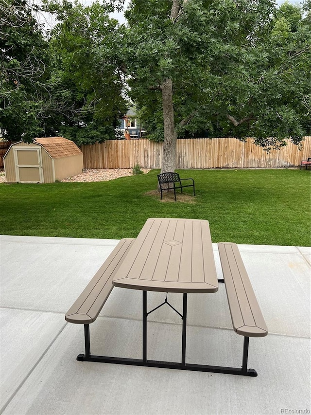 view of home's community featuring an outbuilding, a storage unit, a lawn, a patio area, and fence